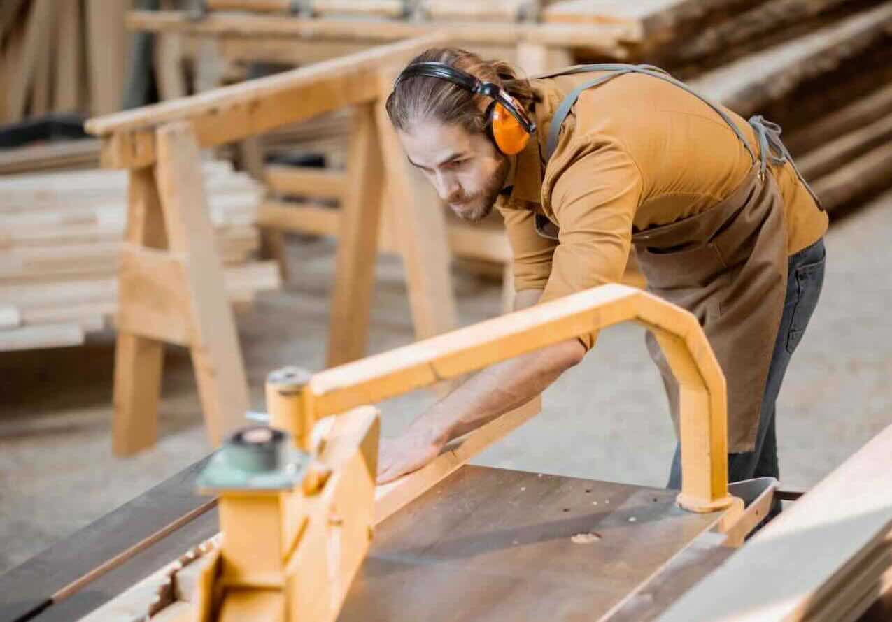 A photo of a man wearing ear protection while providing professional resawing services.